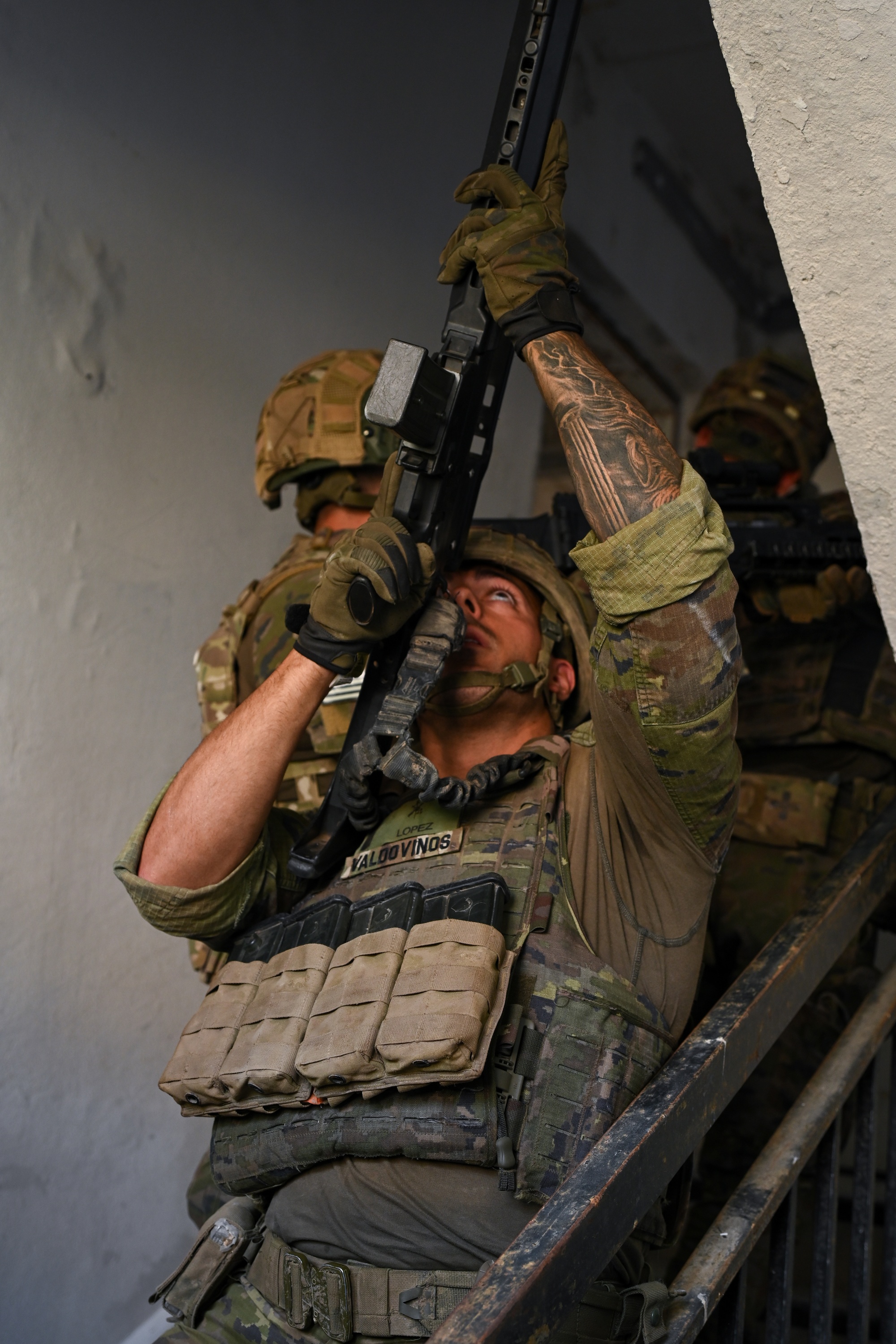 Soldier aiming at a steep upward angle while clearing an interior stairwell