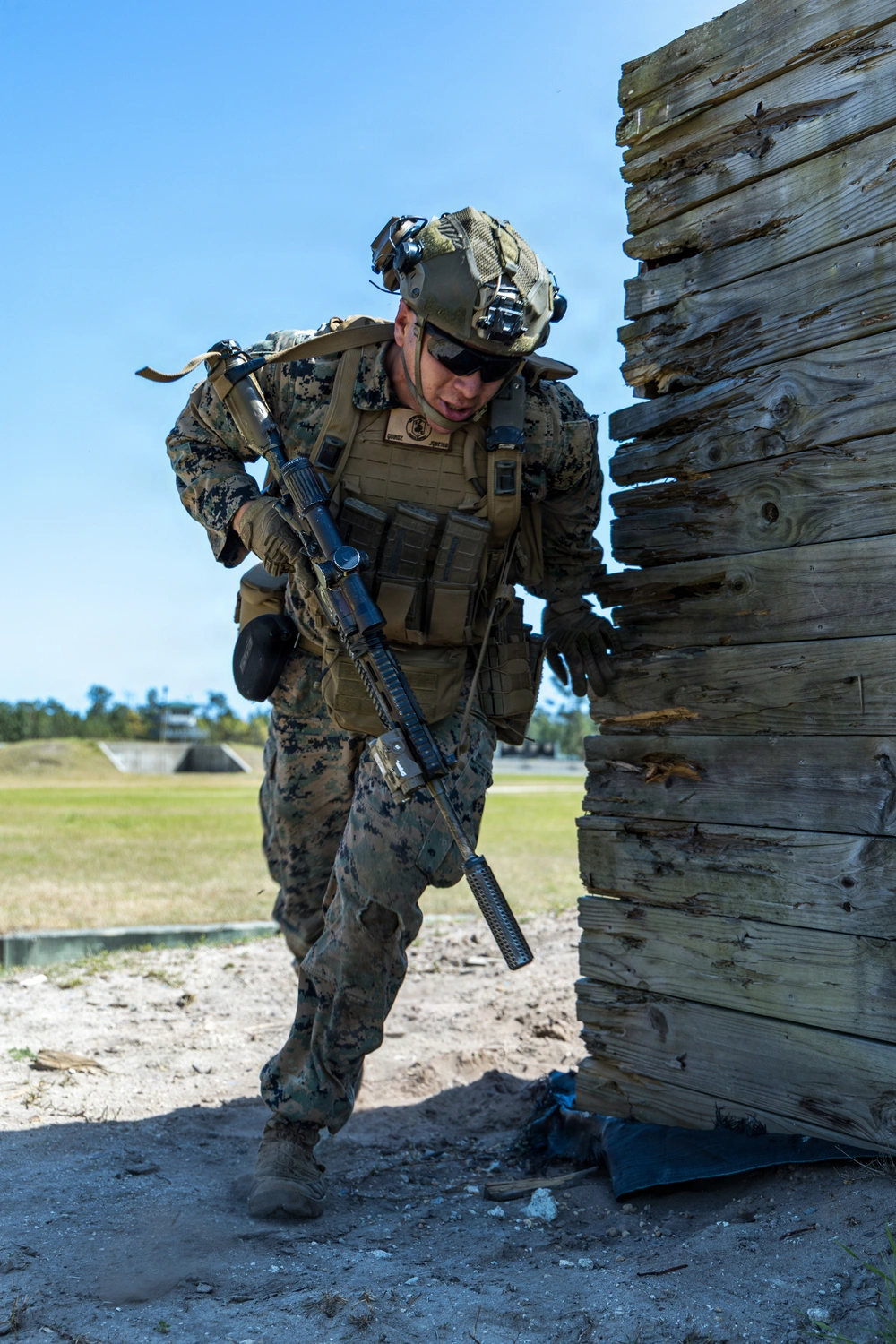 Service member moving around tall wooden cover during a dry-run training exercise
