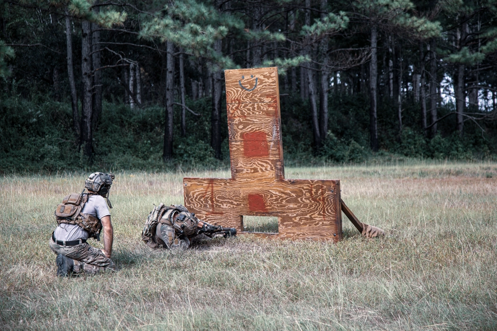 Operator using the low opening of a wooden barricade from a constrained ground position