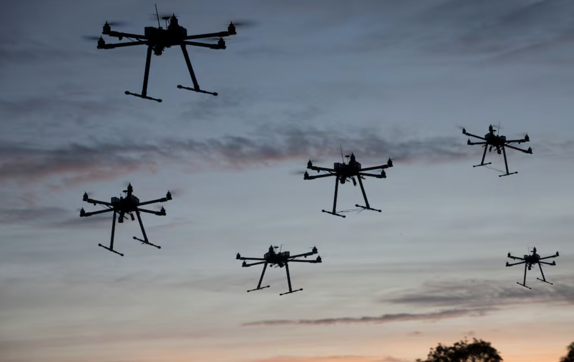 Small uncrewed aircraft silhouetted against a dusk sky